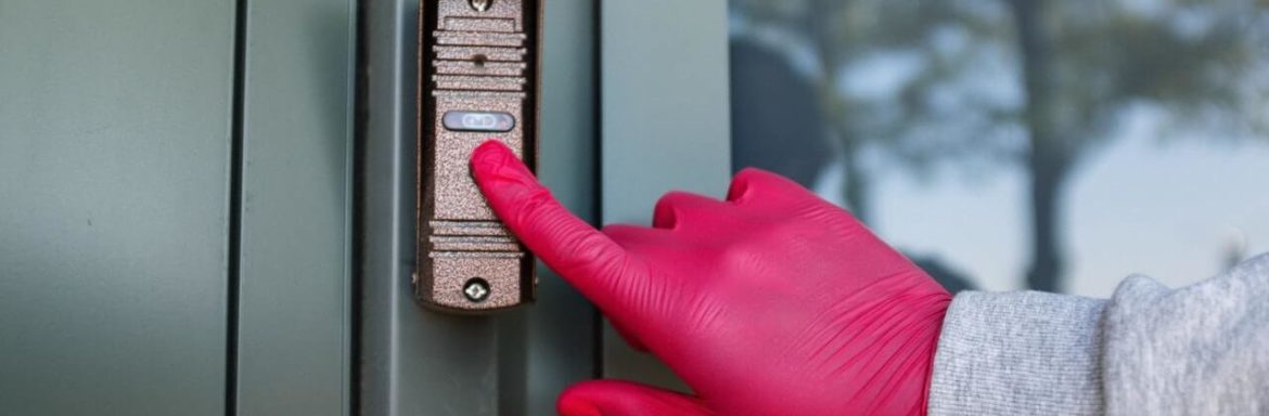 ruka sa gumenom rukavicom stiska dugme za lift